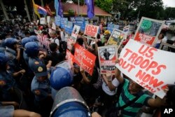 Police block protester trying to get near the U.S. embassy during a rally against the Enhanced Defense Cooperation Agreement (EDCA) between the US and Philippines in Manila, Philippines on Tuesday, Oct. 4, 2016.