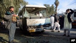 An Afghan security policeman stands guard near a damaged bus after a suicide attack in Nangarhar province east of Kabul, Nov. 23, 2017. 