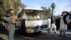 FILE - An Afghan security policeman stands guard near a damaged bus after a suicide attack in Nangarhar province east of Kabul, Afghanistan, Nov. 23, 2017. 