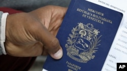 Un migrante venezolano tiene su pasaporte en una cola para obtener un permiso de residencia temporal fuera de la oficina de inmigración en Lima, Perú, 20 de agosto de 2018. REUTERS/Mariana Bazo
