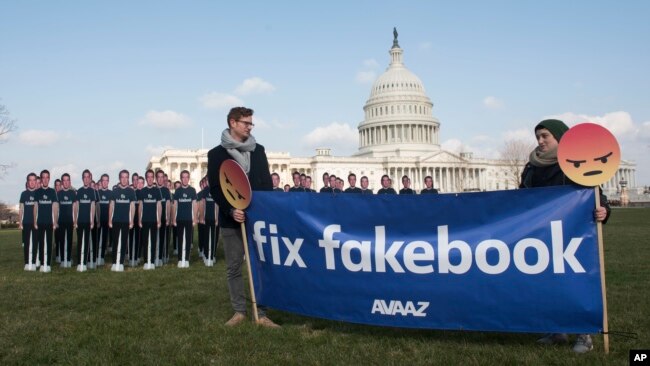 Avaaz campaigners hold a banner in front of 100 cardboard cutouts of Facebook CEO Mark Zuckerberg outside the U.S. Capitol in Washington, April 10, 2018, ahead of his Senate testimony.