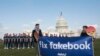 Avaaz campaigners stage 100 cardboard cutouts of Facebook CEO Mark Zuckerberg to draw attention to millions of fake accounts still spreading disinformation on the social media platform, Washington, April 2018.