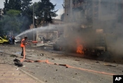 FILE - In this photo released by the Syrian official news agency SANA, Syrian citizens and firefighters gather at the scene where one of rockets hit the Dubeet hospital in the central neighborhood of Muhafaza in Aleppo, May 3, 2016.