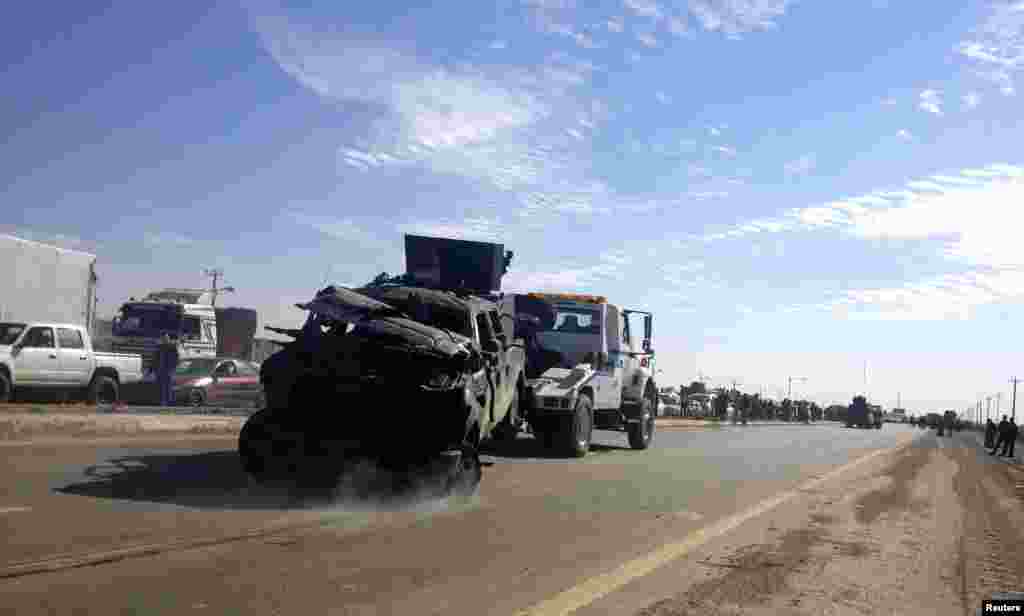 A police vehicle is towed after a suicide bomb attack in Taji, Iraq, Feb. 5, 2013.