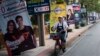 A woman rides a bicycle past electoral posters in Bangkok on March 17, 2019, ahead of the March 24 general election. 