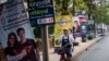 A woman rides a bicycle past electoral posters in Bangkok on March 17, 2019, ahead of the March 24 general election. 