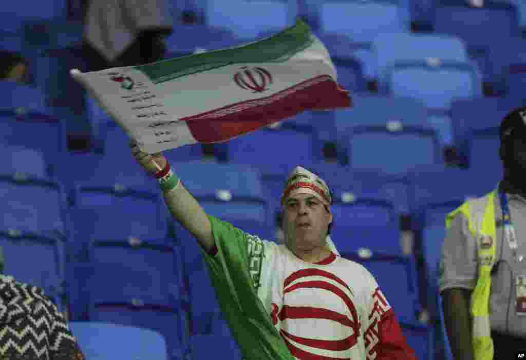 یک مرد ایرانی با پرچم جمهوری اسلامی و لباسی به شکل پرچم در بازی ایران و عراق حضور یافت.