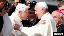 Pope Francis, right, greets Emeritus Pope Benedict XVI before a mass in Saint Peter's square at the Vatican, Sept. 28, 2014. 