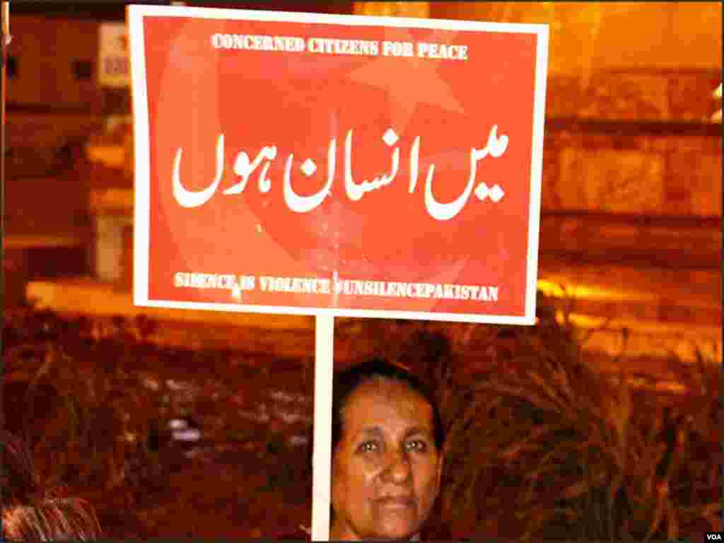 کراچی: احتجاج میں شریک خاتون بینر اٹھائے ہوئے