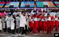 FILE - North and South Koreans wave flags during the closing ceremony of the 2018 Winter Olympics in Pyeongchang, South Korea, Feb. 25, 2018.