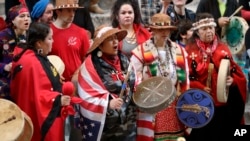 FILE - Native American tribal members sing and drum in the rotunda of the Capitol in Olympia, Washington. The gathering was part of Native American Indian Lobby Day and supported issues such as the awareness of missing and murdered indigenous women in Washington state. 