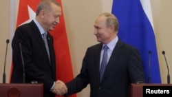 Predsednici Turske i Sirije rukuju se na konferenciji za novinare posle razgovora u Sočiju, u Rusiji, 22. oktobar 2019.