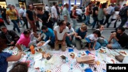 Anti-government protesters eat as they break their fast on the first day of the holy month of Ramadan at Taksim Square in Istanbul, Turkey, July 9, 2013. 