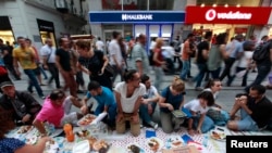 Anti-government protesters eat as they break their fast on the first day of the holy month of Ramadan at Taksim Square in Istanbul, Turkey, July 9, 2013. 