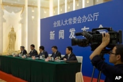 FILE - Chinese officials answer questions about a law regulating overseas non-governmental organizations (NGOs) during a press conference at the Great Hall of the People in Beijing, China, April 28, 2016.