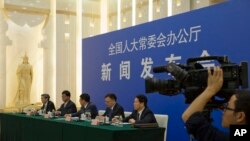 FILE - Chinese officials answer questions about a law regulating overseas non-governmental organizations (NGOs) during a press conference at the Great Hall of the People in Beijing, China, April 28, 2016. 