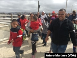 Members of the Central American migrants caravan arrive at the "El Chaparral" pedestrian crossing on their way to U.S. Customs and Border Patrol, at the U.S.-Mexico border in Tijuana, Mexico, April 29, 2018. (A. Martinez/VOA)