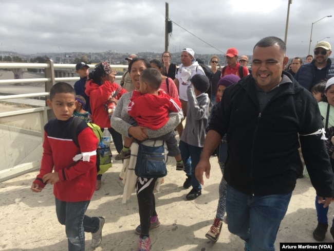 Members of the Central American migrants caravan arrive at the "El Chaparral" pedestrian crossing on their way to U.S. Customs and Border Patrol, at the U.S.-Mexico border in Tijuana, Mexico, April 29, 2018. (A. Martinez/VOA)