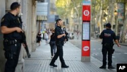 Armed police officers patrol a street in Las Ramblas, Barcelona, Spain, Aug. 18, 2017. Catalonia is to deploy more police and erect barriers as authorities examine links to Islamist militant cells in Europe following last week's attacks.