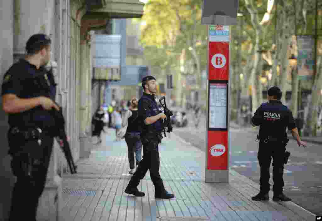 Armed police officers patrol a street in Las Ramblas, Barcelona, Spain, Aug. 18, 2017.