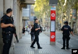 FILE - Armed police officers patrol a street in Las Ramblas, Barcelona, Spain, Aug. 18, 2017.