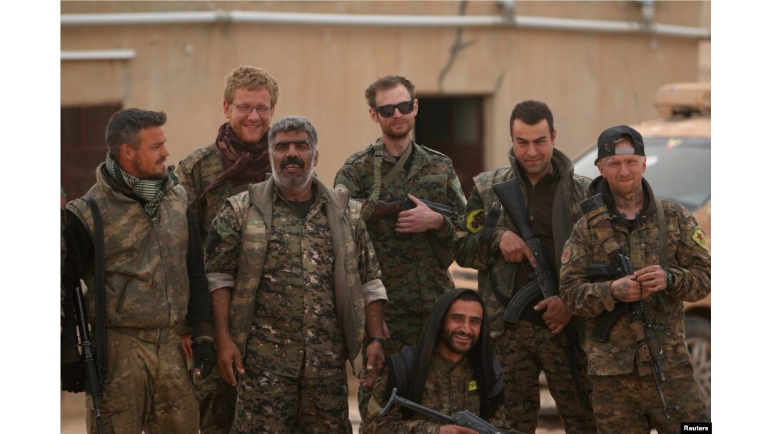 Syrian Democratic Forces (SDF) fighters pose with foreign volunteer fighters inside Tabqa military airport after taking control of it from Islamic State fighters, west of Raqqa city, Syria April 9, 2017.