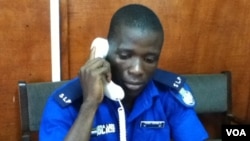 Sheka Conteh answers phones at the police call centre, Freetown, February 1, 2013. (N. de Vries/VOA)