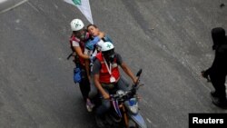 Un manifestante herido es socorrido por miembros de la Cruz Verde durante una manifestación el 5 de junio en Caracas.