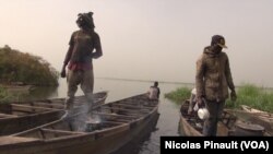 
Des réfugiés nigérians après une nuit de pêche débarquent dans le village de Tagal, Tchad, le 24 avril 2017. (VOA/Nicolas Pinault)