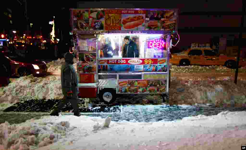 Dec. 28: A man walks past a food cart in New York City. The blizzard dumped 29 inches of snow on some areas and severely disrupted air and rail travel. (Gary Hershorn/Reuters)