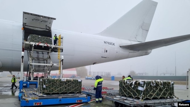 Workers and Ukrainian servicemen unload a shipment of ammunition delivered as part of U.S. security assistance to Ukraine, at the Boryspil International Airport outside Kyiv, Ukraine November 14, 2021. (Press service of the U.S. Embassy in Ukraine/Handout