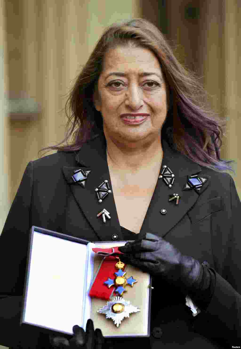 FILE - Architect Zaha Hadid poses for photographs with her Dame Commander of the Order of the British Empire (DBE) medal, after it was awarded to her by Britain's Princess Anne during an Investiture Ceremony at Buckingham Palace, in London, Nov. 7, 2012. 