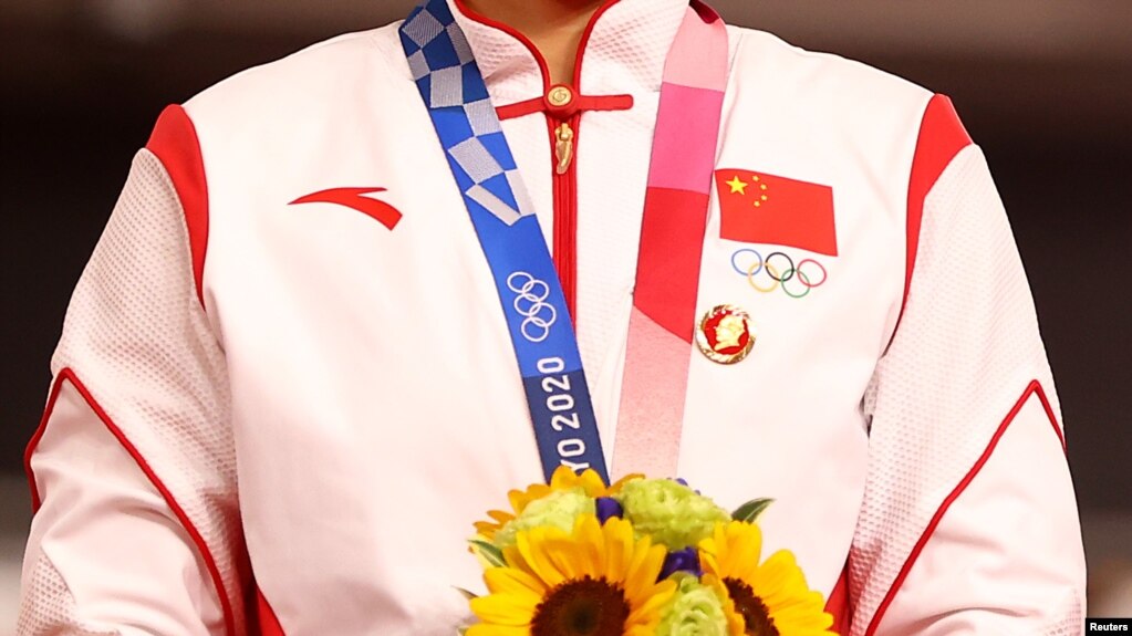 中国场地自行车女子团体赛金牌得主在东京奥运会领奖台上违反奥林匹克宪章，佩戴中共前领导人毛泽东的像章。（2021年8月2日）(photo:VOA)
