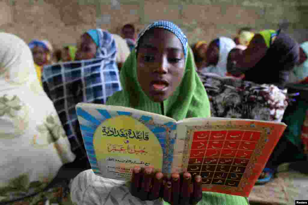 Nigeriyaning janubiy Kano shahrida joylashgan Qur'on maktabida yosh qiz Qur'on o'qimoqda. 21-iyul, 2012-yil.