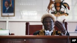 Judge Stephen Kavuma reads the verdict at Uganda’s Constitutional court, invalidating an anti-gay bill signed into law earlier this year, saying it was illegally passed and is therefore unconstitutional, Aug.1, 2014.