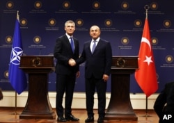 NATO Secretary General Jens Stoltenberg, left, and Turkish Foreign Minister Mevlut Cavusoglu shake hands afer a joint news conference in Ankara, Turkey, April 21, 2016.