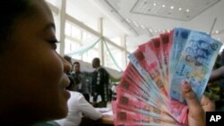 A woman holds Ghana's currency (File)