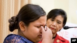 FILE - Rep. Judy Chu, D-Calif., watches as Fiorella Zuniga of Dumfries, Va. — whose parents are undocumented immigrants from Peru — cries during a news conference in Washington, Dec. 9, 2015. Chu said she'll be bringing an immigrant as her guest for a speech next week by President Donald Trump because Trump "needs to see the people he has hurt."