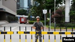 Seorang prajurit Tentara Pembebasan Rakyat China(PLA) menjaga pintu masuk markas Garnisun Hong Kong PLA di Kawasan Pusat Bisnis di Hong Kong, 29 Agustus 2019. (REUTERS/Anushree Fadnavis)