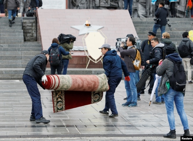 Workers remove carpet after the flower laying ceremony by North Korean leader Kim Jong Un, at a navy memorial in Vladivostok, Russia, April 26, 2019.