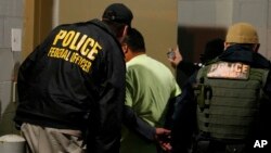 Petugas Imigrasi dan Bea Cukai AS (ICE) menangkap seorang target dalam penggerebekan di Richmond, Va, 22 Oktober 2018. (Foto: dok).