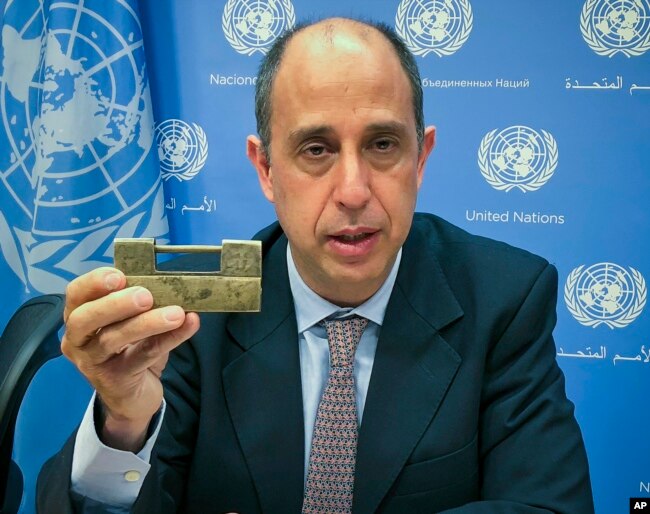 FILE - Tomas Ojea Quintana, the U.N. special investigator on human rights in North Korea, holds up a lock given to him by North Koreans who escaped from the country, during a press conference, Oct. 23, 2018, at U.N. headquarters in New York.