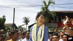 Aung San Suu Kyi, leader of Burma's democratic opposition, smiles to supporters near Bago, some 100 km north of Rangoon, August 14, 2011