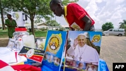 A vendor arranges portraits of Pope Francis outside of the Lubaga Cathedral in Kampala, Uganda, Nov. 13, 2015. 