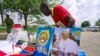 FILE - A vendor arranges portraits of Pope Francis outside of the Lubaga Cathedral in Kampala, Uganda, Nov. 13, 2015. 