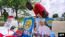 A vendor arranges portraits of Pope Francis outside of the Lubaga Cathedral in Kampala, Uganda, Nov. 13, 2015. The pope will be in Uganda on November 28 and 29 (AFP/ ISAAC KASAMANI).