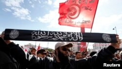2013年1月14日突尼斯革命兩週年﹐一名薩拉菲派穆斯林極端分子高舉標語