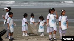 Học sinh nhặt rác trên bãi biển ở Karachi. 