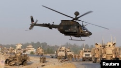 U.S. troops assess damage to an armored vehicle in a NATO-led international security force in Afghanistan's Jalalabad province, Aug. 24, 2014. 