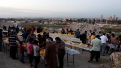 Orang-orang berkumpul untuk berbuka puasa selama bulan puasa Ramadhan, di Mosul, Irak, 15 April 2021. (Foto: REUTERS/Khalid Al-Mousily)